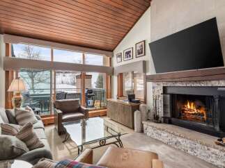Experience luxury living in this stunning property, featuring a cozy fireplace and a sleek, modern TV.