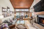 Experience luxury living in this stunning property, featuring a cozy living room with a fireplace and a large TV.