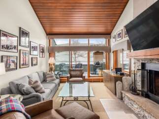 Experience luxury living in this stunning property, featuring a cozy living room with a fireplace and a large TV.