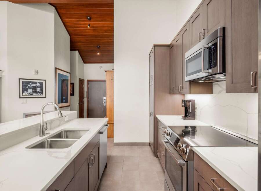 Step into this stunning kitchen, featuring sleek cabinetry and modern appliances.