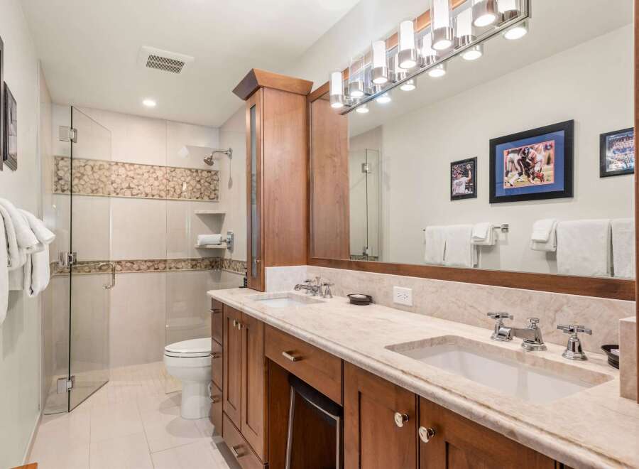 Step into luxury with this stunning bathroom featuring a spacious vanity with dual sinks and ample storage.