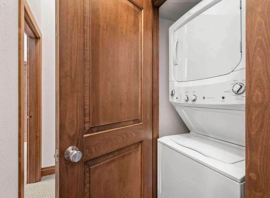 This stunning property boasts a convenient laundry area, featuring a modern stacked washer and dryer.