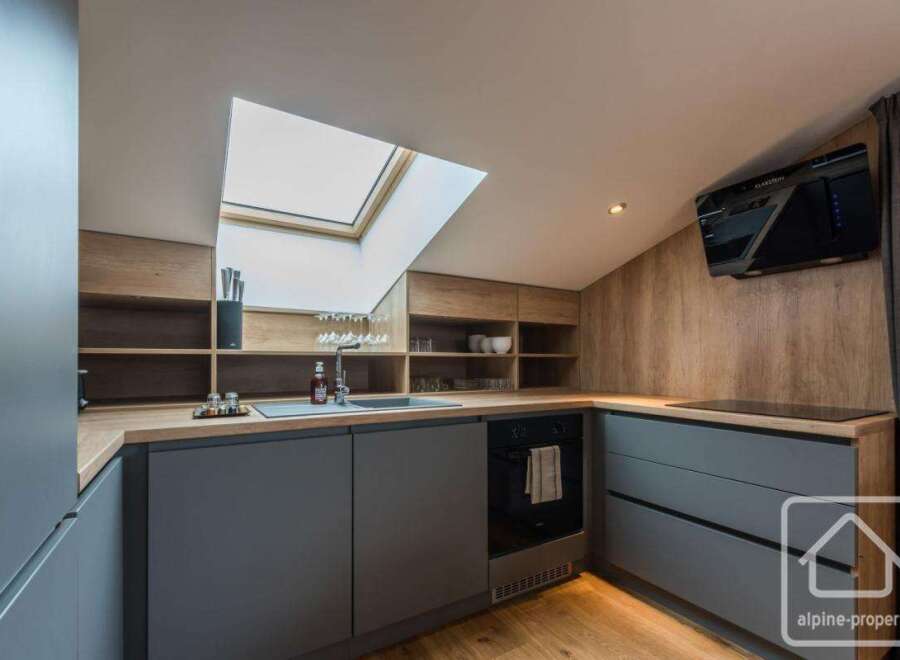 Discover modern living in this stylish kitchen, featuring sleek gray cabinetry and warm wooden accents.