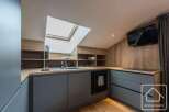 Discover modern living in this stylish kitchen, featuring sleek gray cabinetry and warm wooden accents.