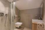 This modern bathroom features a sleek shower, a wall-mounted toilet, and a stylish vanity.