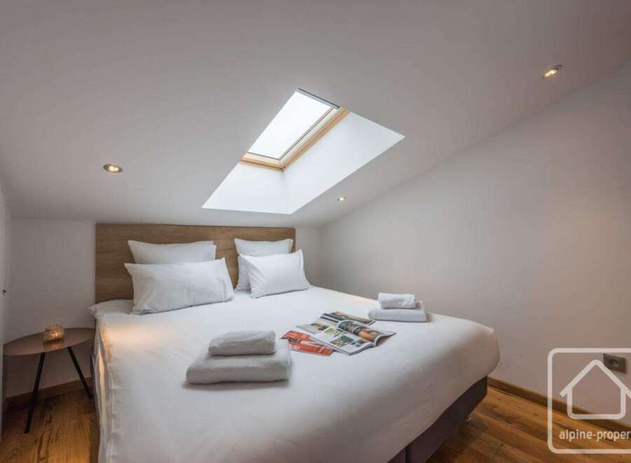 Discover the epitome of comfort in this stunning bedroom, featuring a unique skylight that bathes the space in natural light.