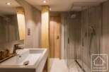 This modern bathroom features a sleek design with a spacious walk-in shower and a stylish sink.