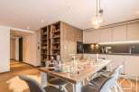 This stunning property boasts a modern kitchen with sleek cabinetry and a cozy dining area, perfect for entertaining.