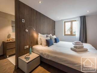 This stunning bedroom boasts a modern design with a wooden accent wall, creating a warm and inviting atmosphere.