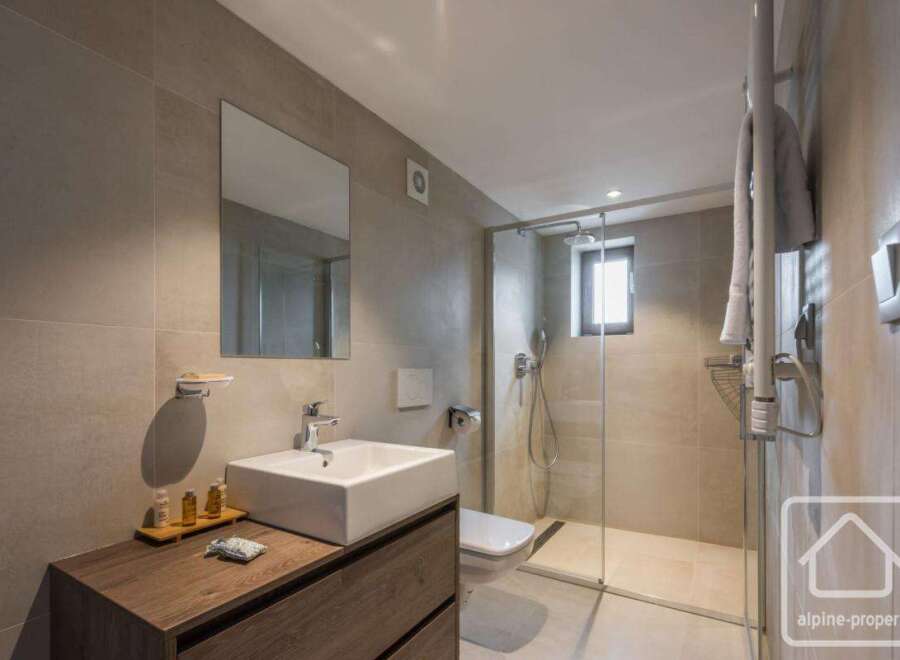 This modern bathroom features a sleek design with a spacious walk-in shower and a stylish vanity.