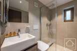 This modern bathroom features a sleek design with a glass shower, a stylish sink, and a convenient toilet.