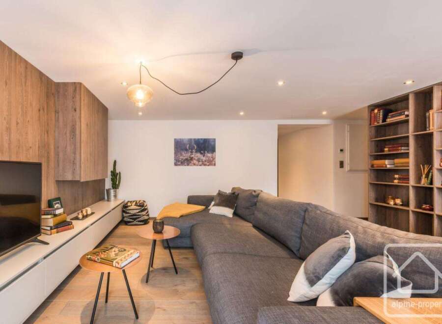 This stunning property boasts a modern living space with a cozy sectional sofa, perfect for relaxing.