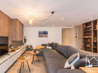 This stunning property boasts a modern living space with a cozy sectional sofa, perfect for relaxing.