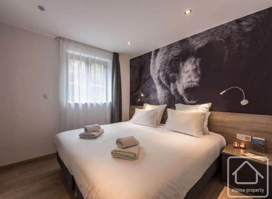 This cozy bedroom features a comfortable bed with fresh linens and towels, perfect for a relaxing stay.