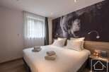 This cozy bedroom features a comfortable bed with fresh linens and towels, perfect for a relaxing stay.