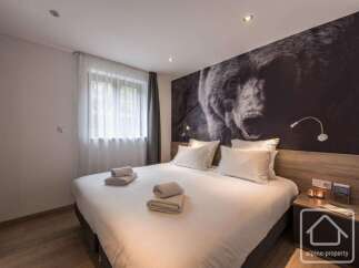 This cozy bedroom features a comfortable bed with fresh linens and towels, perfect for a relaxing stay.