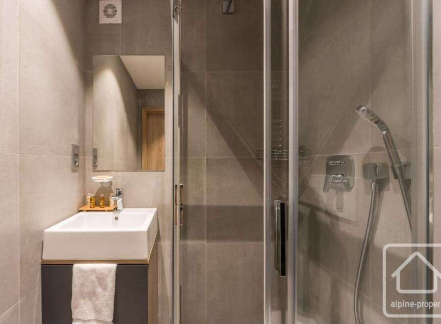 This modern bathroom features a sleek, minimalist design with a glass shower enclosure and a stylish vanity.