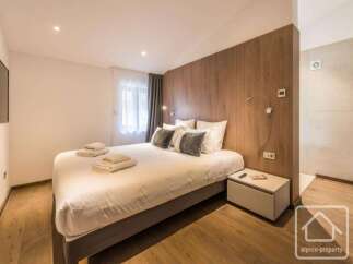 Experience luxury in this stunning bedroom featuring a comfortable bed and elegant wooden accents.