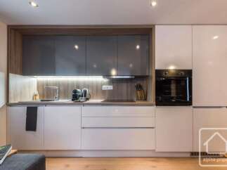 This modern kitchen boasts sleek, white cabinetry and a stylish design.