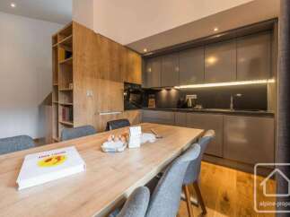 This modern kitchen features a sleek design with wooden cabinetry and a spacious dining area.