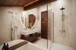 Experience luxury in this stunning bathroom, featuring a modern design with a touch of rustic charm.