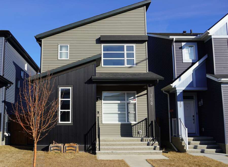 This stunning modern home boasts a unique architectural design with a mix of textures and colors.