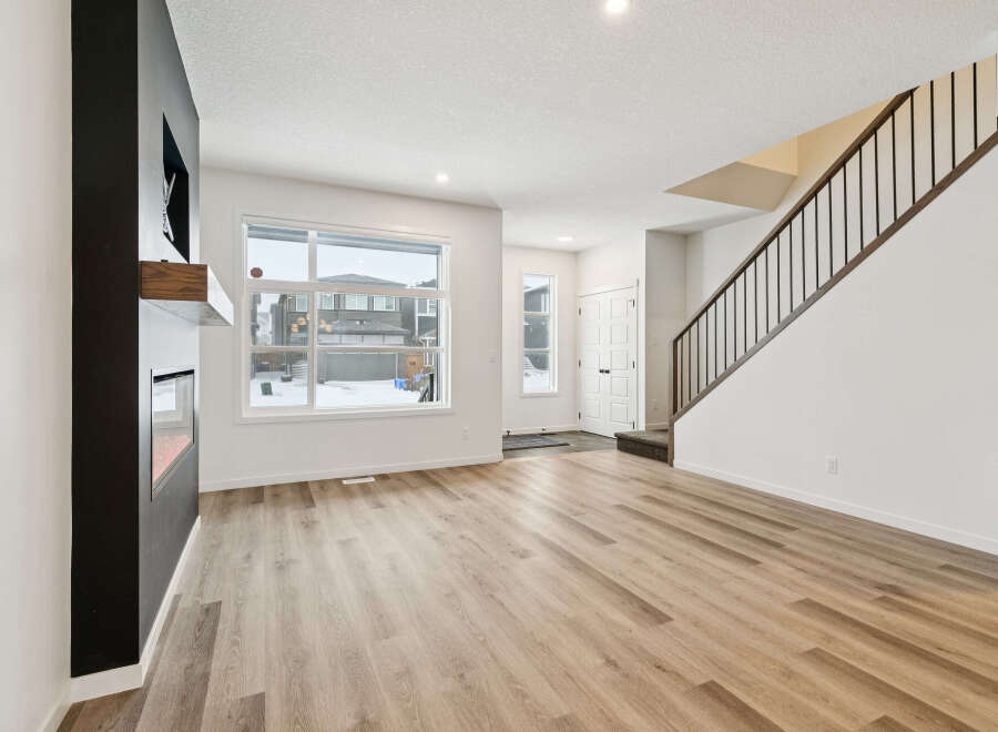 Step into this stunning home featuring a modern fireplace and elegant staircase.