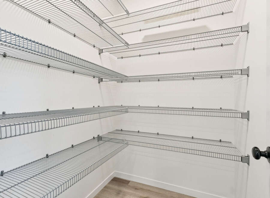 This walk-in closet offers ample storage with its multi-level wire shelving system.