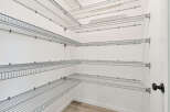 This walk-in closet offers ample storage with its multi-level wire shelving system.