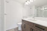 This modern bathroom features a sleek vanity with ample storage and a pristine white countertop.