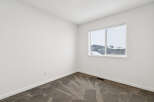 This bright and airy room features neutral walls and a cozy carpet, creating a versatile space.