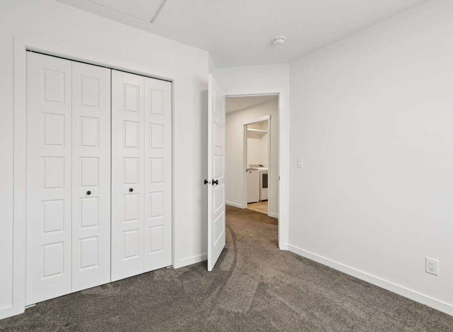 Step into this bright and airy bedroom, featuring a spacious closet and neutral color palette.