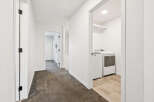 Step into this bright and airy hallway, featuring pristine white walls and elegant dark carpet.