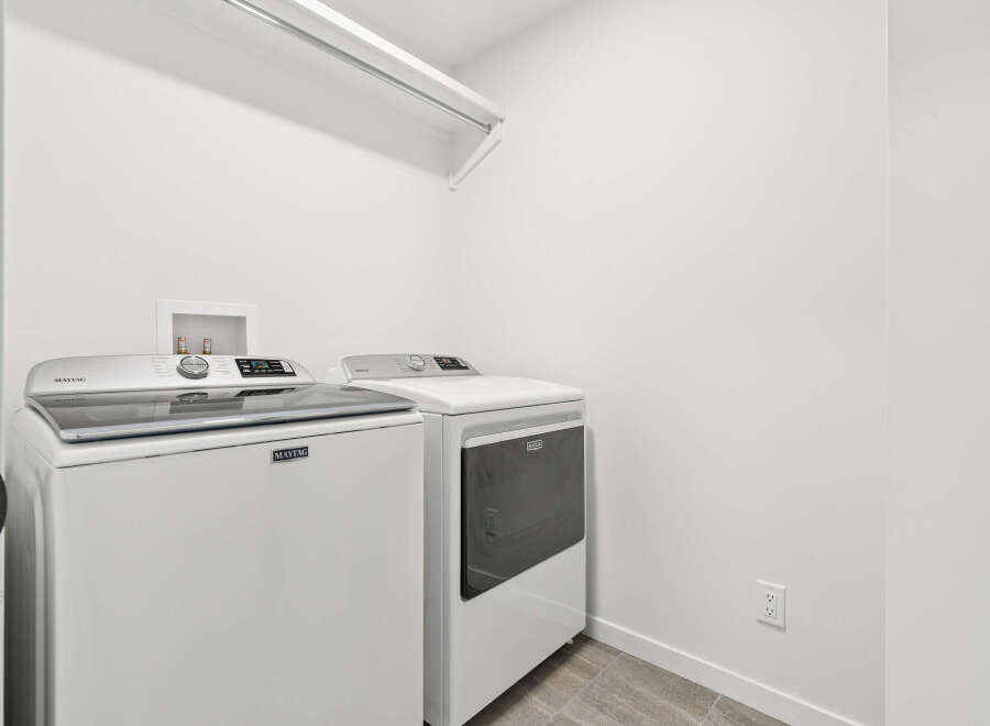 This laundry room features a modern Maytag washer and dryer set, perfect for efficient and stylish laundry days.