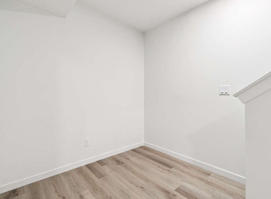 This stunning property boasts a modern interior with pristine white walls and elegant wood-look flooring.