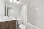 Step into this modern bathroom, featuring sleek white subway tile and a contemporary vanity.