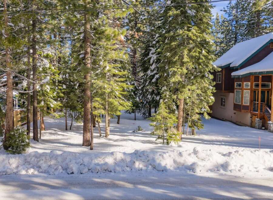 Nestled amidst a serene winter landscape, this property offers a picturesque setting with snow-covered trees and a charming house.