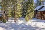 Nestled amidst a serene winter landscape, this property offers a picturesque setting with snow-covered trees and a charming house.
