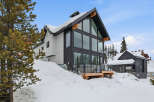 This stunning modern home offers a luxurious mountain retreat with its sleek design and expansive windows.