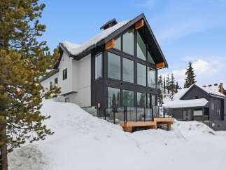 This stunning modern home offers a luxurious mountain retreat with its sleek design and expansive windows.
