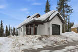 This stunning property boasts a modern design with a snow-covered roof, perfect for a winter getaway.