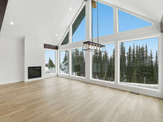 This stunning property boasts a bright and airy living space, highlighted by expansive windows that offer breathtaking views of the surrounding natural landscape.