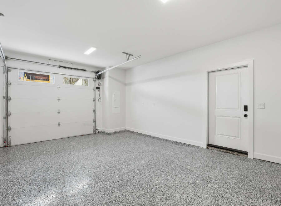 This spacious garage features a clean and modern design, perfect for storing vehicles and other belongings.