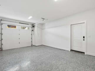 This spacious garage features a clean and modern design, perfect for storing vehicles and other belongings.