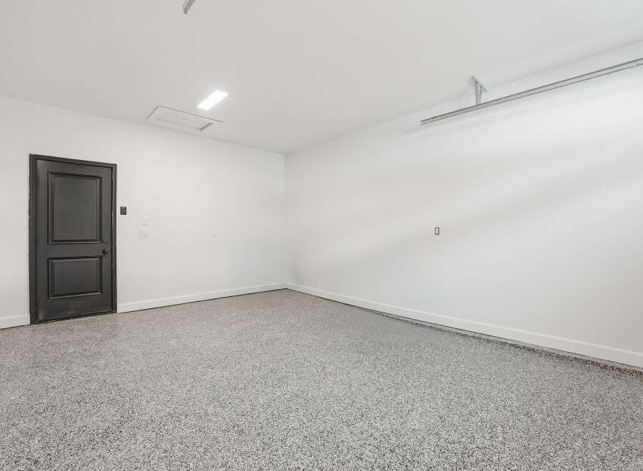This spacious garage offers a clean and modern aesthetic, perfect for storing vehicles or creating a functional workspace.