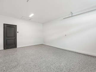 This spacious garage offers a clean and modern aesthetic, perfect for storing vehicles or creating a functional workspace.