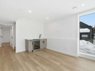 This stunning property boasts a modern interior with a sleek wet bar, perfect for entertaining guests.