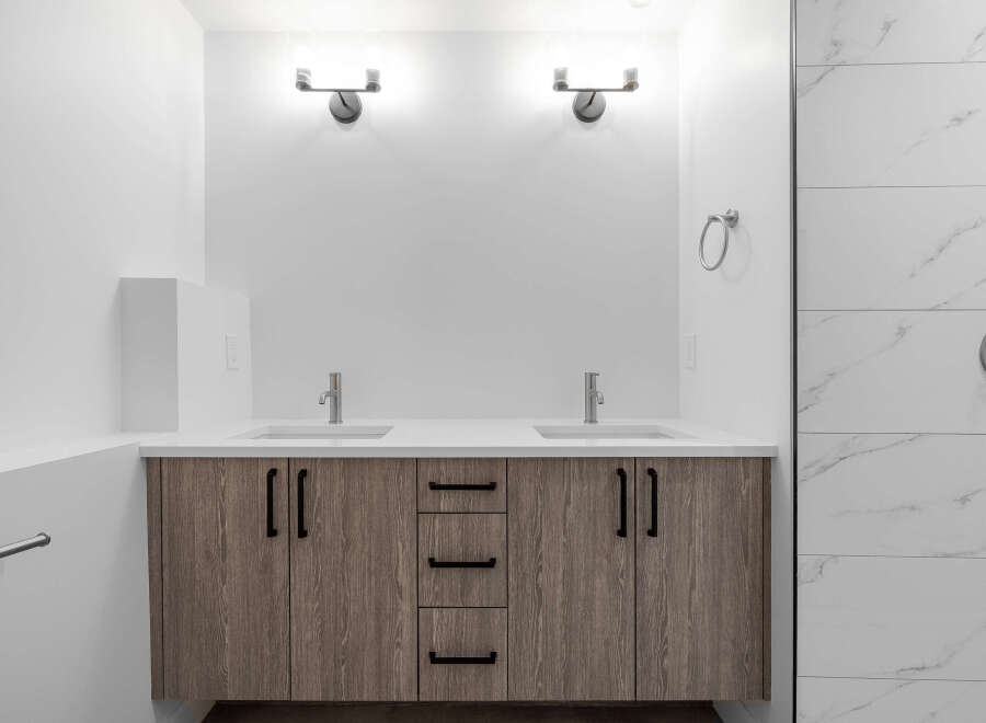This modern bathroom boasts a sleek design with a double vanity and ample storage.