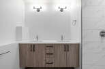 This modern bathroom boasts a sleek design with a double vanity and ample storage.
