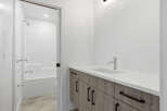 This modern bathroom boasts a sleek design with a pristine white countertop and a stylish faucet.